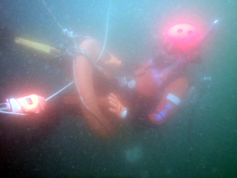 潜水訓練中浮き輪をくぐり抜ける潜水士